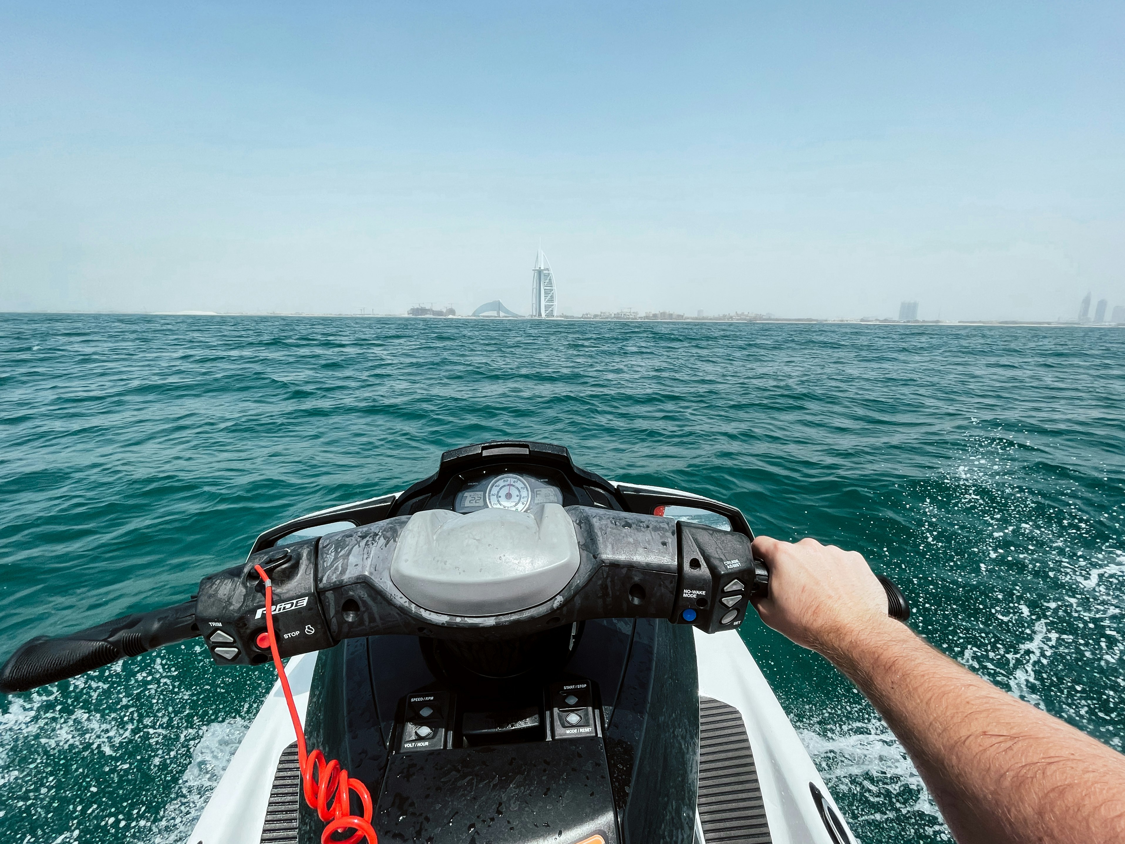 person in black and red life vest riding on white boat during daytime